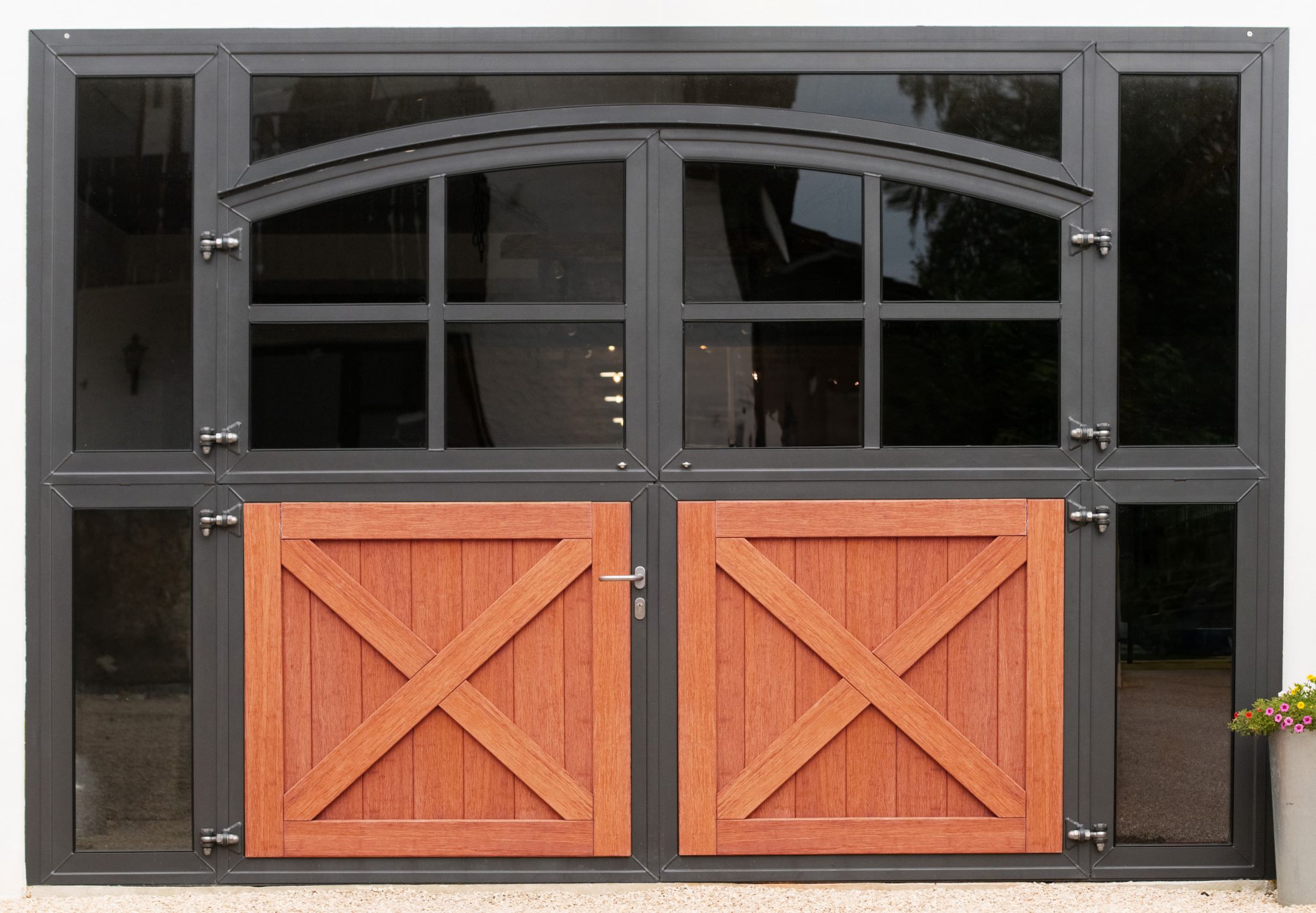 Porte de box haut de gamme par Röwer & Rüb avec éléments en acier thermolaqué et panneaux en bois. La conception à double battant combine des fenêtres en verre et du bois pour un design élégant. Conseils d’entretien du revêtement en poudre