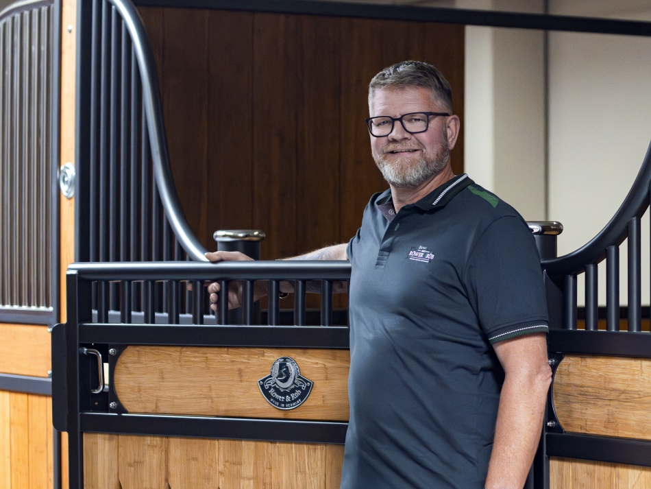 Gustav Vindelov the new Röwer & Rüb distributor stands in front of a horse stall