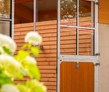 A large half-open stable door with flowers in front of it