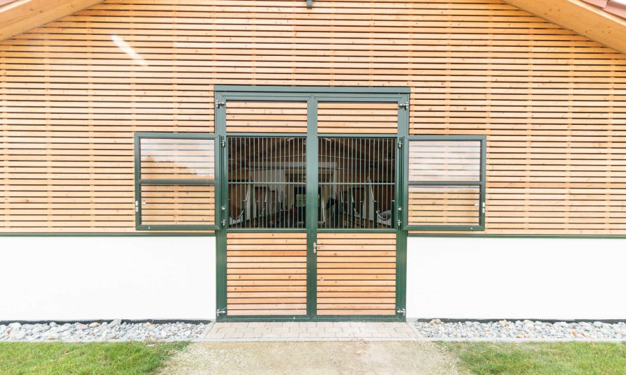 Röwer & Rüb Tor mit angepasster Holzfüllung der Fassade, pulverbeschichtet grün