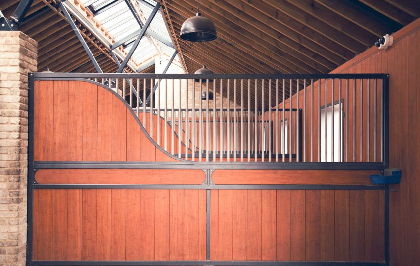 Röwer & Rüb Trennwände pulverbeschichtet mit geschwungener Sichtblende für ein ruhige Fütterung im Pferdestall. Das besondere Design ergibt sich aus der Querbohle.